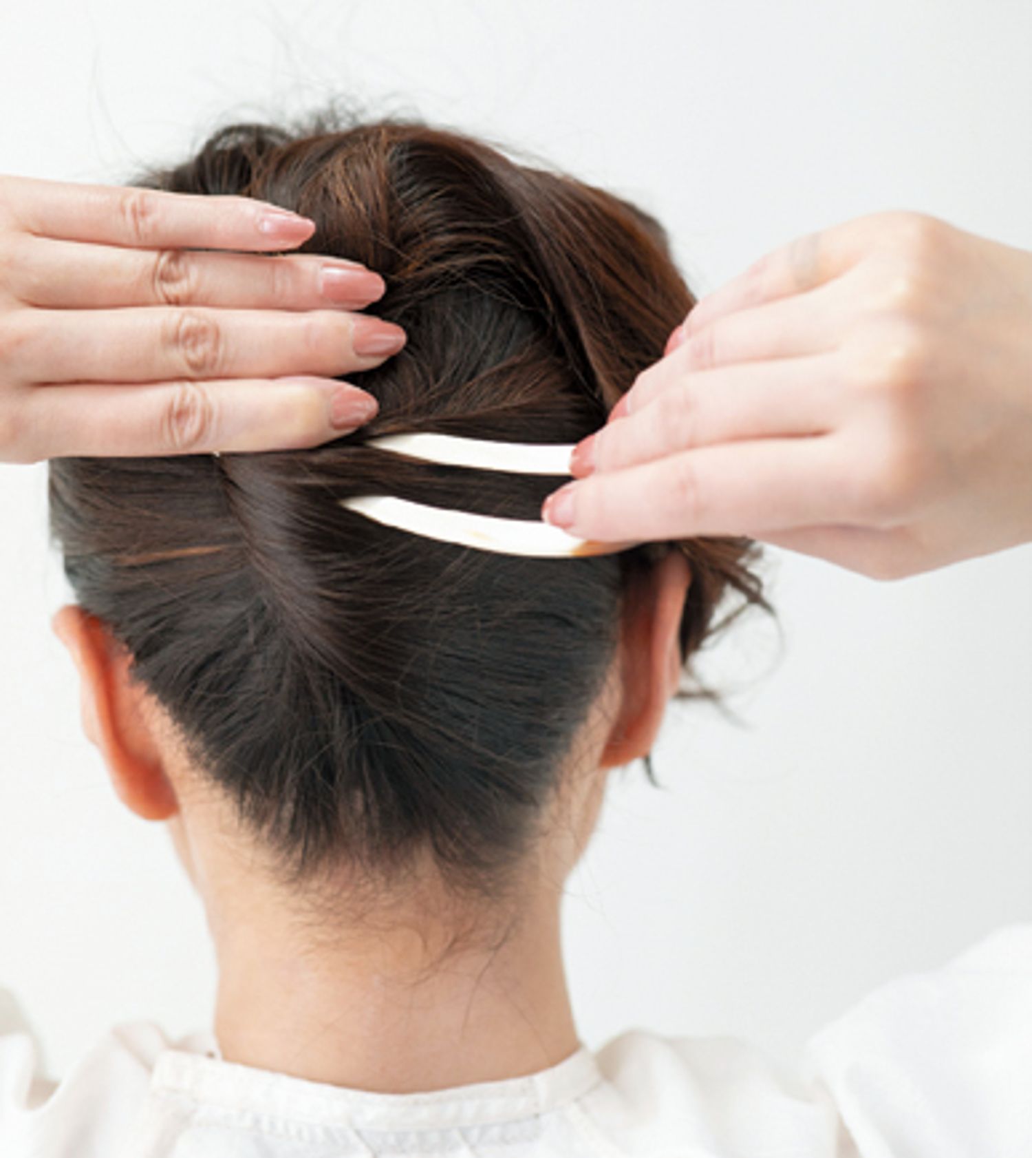 基本の夜会巻きを参考にねじり上げたら、ねじった方向にかんざしの裏が上になるよう挿し込む。