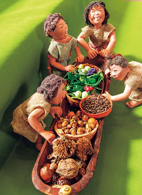 採取してきた食べ物を載せた舟 を押す子どもたち。人形は、石 塑粘土や木粉粘土を使って成形。 木舟の上には、ドングリやクルミなどの木の実や、粘土で作ら れた野菜がたっぷり積まれてい る。まだ幼い子どもたちの息づ かいや、喜びが伝わってくる。