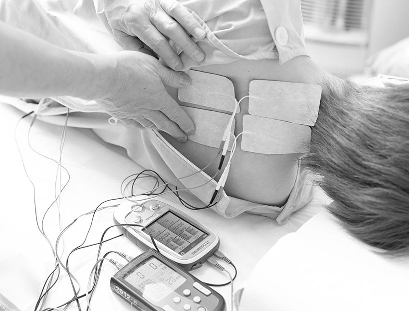 手や腕に痛みやしびれがある人は肩甲骨まわりが過度に緊張していることも多く、最初に低周波治療器を使って緊張をほぐす。