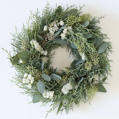 ユーカリ・ポポラスの葉に蕾をたっぷり加え、コニファー‘ブルーアイス’とスターチスを加えたリースです。繊細な蕾とコニファーの葉で印象がぐっと優しくなります。蕾を利用すると印象がまた変わるのもユーカリの魅力の一つです。木のつるで編んだリースベース（約20cm）を利用。