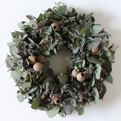 ポポラス、グニー、丸葉の3種のユーカリに、ベルガムナッツの実を加え、リモニウムをアクセントに加えました。ベルガムナッツもユーカリの1種で、ユニークな形状の実は存在感抜群です。木のつるで編んだリースベース（約20cm）を利用。