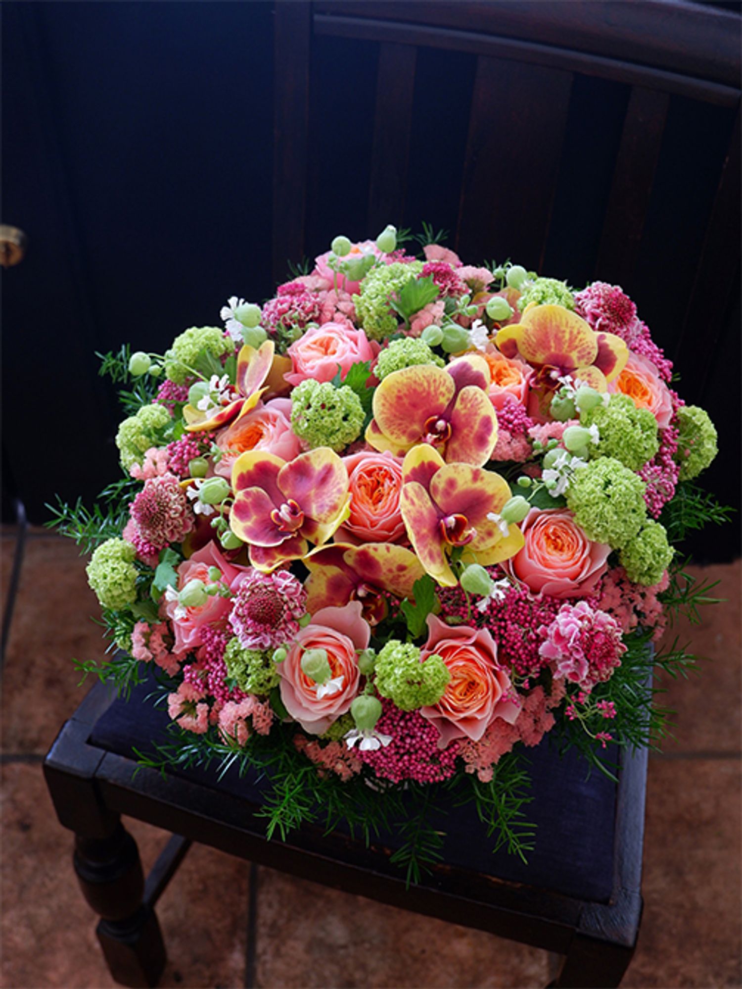 個性的なファレノプシス‘こはく’を使ったアレンジに、ライスフラワー‘マゼンタ’を加えました。ほかの花形とは異なるライスフラワーならではの粒々感がよいアクセントになっています。バラ‘コーラルハート’、スカビオサ‘コットンキャンディースクープ’、スターチス、シレネ‘小布施の郷’、ビバーナム・スノーボールなどを使用。