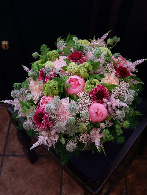 濃淡のピンクに明るいグリーンをたっぷり加えたナチュラルなアレンジです。ライスフラワー‘ピンク’は大きな花と花のすき間を埋めるのに大活躍。シャクヤク‘エッチドサーモン’、カーネーション、スカビオサ、アストランティア、ビバーナム・スノーボール、ゼラニウムなどを使用。