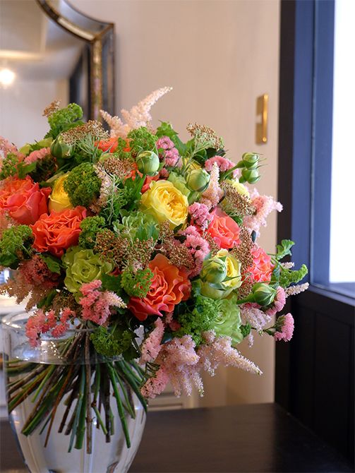 バラとライスフラワー‘ゴールド’の花合わせで、結婚のお祝いのブーケを制作しました。シックな金色が少し加わるだけで、落ち着き感と同時にゴージャス感も。バラは‘ブラッドオレンジ’と蕾付きの‘カタリナ’、‘スパークグリーン’をセレクト。ほかにスターチス‘トレモロフレア’、アスチルベ‘ライトピンク’、ビバーナム・スノーボールなどを使用しています。