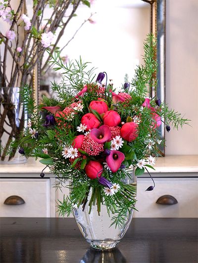 和歌山県のクリニックへ、待合室を華やかに飾る初夏の花を。シャクヤク‘コーラルチャーム’とカラー‘ピンクパピー’のあでやかなピンクをメインに、マーガレット‘ドリームカシス’、クレマチス‘篭口’を加え、アスパラガス・スプレンゲリーをたっぷりあしらいました。