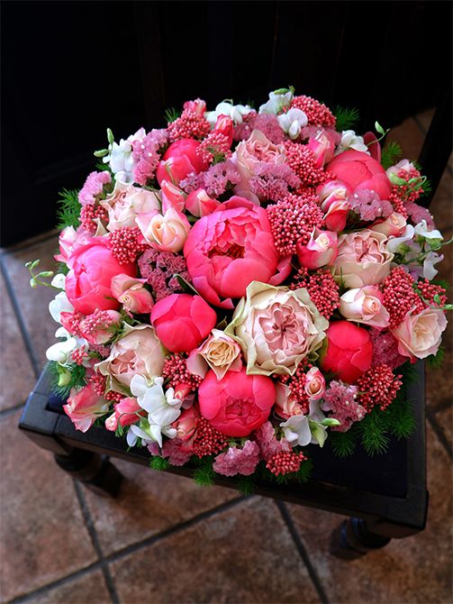 ライスフラワー‘マゼンタ’とシャクヤク‘コーラルチャーム’の濃いピンクに、バラの‘ストロベリーモンローウォーク’と‘マロンフォレスト’、スターチス‘レッドオレンジ’、宿根スイートピーなどを合わせたアレンジ。イチゴが大好きな友人へ、イチゴ色の贈り花を。