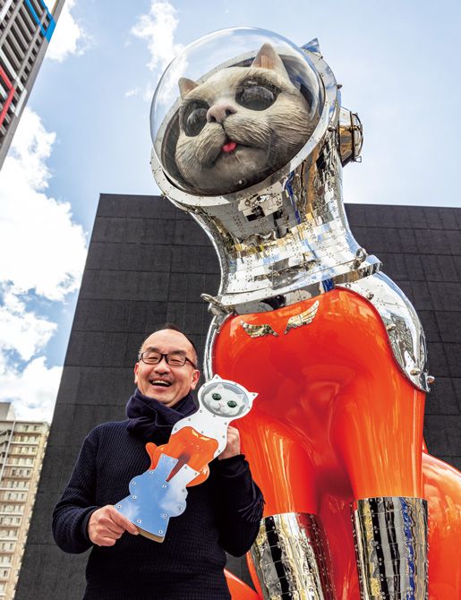 漆黒の建物の前に対照的な朱色の作品を置くことで、互いに引き立て合う関係性を目指したと話すヤノベさん。館内では、《SHIP’S CAT（Muse）》関連のミュージアムグッズも数々揃う。