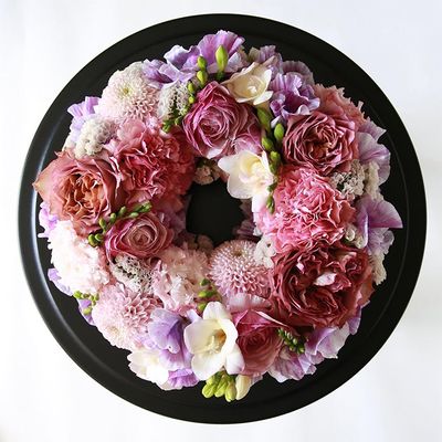 ダリアやスイートピー、フリージアなど、カーネーションやリシアンサスとは異なる花形を加えて変化を出してみました。ダリアのピンクはカーネーションにはない透明感があり、花弁の質感の違いもリースの表情を豊かなしてくれます。直径約20cmのフローラルフォームを使用。