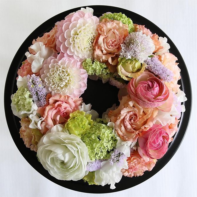 ピンクからアプリコット色のグラデーションでリースを作ってみました。ボリューム感のあるダリアやリシアンサスのほかに、ころんとした花形が愛らしいラナンキュラス、淡い緑の花房が繊細なビバーナム。スノーボールを加えました。直径約20cmのフローラルフォームを使用。