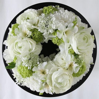白と緑の色合わせで初夏のさわやかな気候を感じさせるリースに。白花はリシアンサス、ラナンキュラス、アルストロメリア、オルレアなど。淡い緑はビバーナム・スノーボールです。直径約20cmのフローラルフォームを使用。