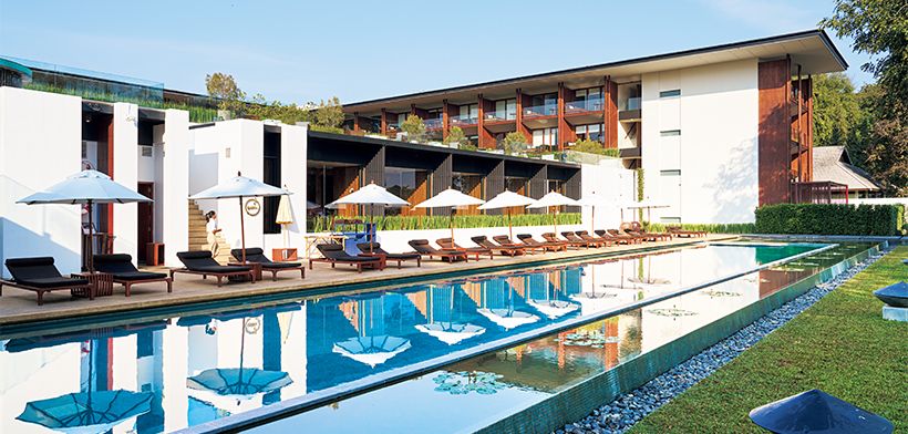 プールから客室棟を望む。ホテルは石、木、水、3つの素材を巧みに組み合わせたシンプルで直線的なデザイン。