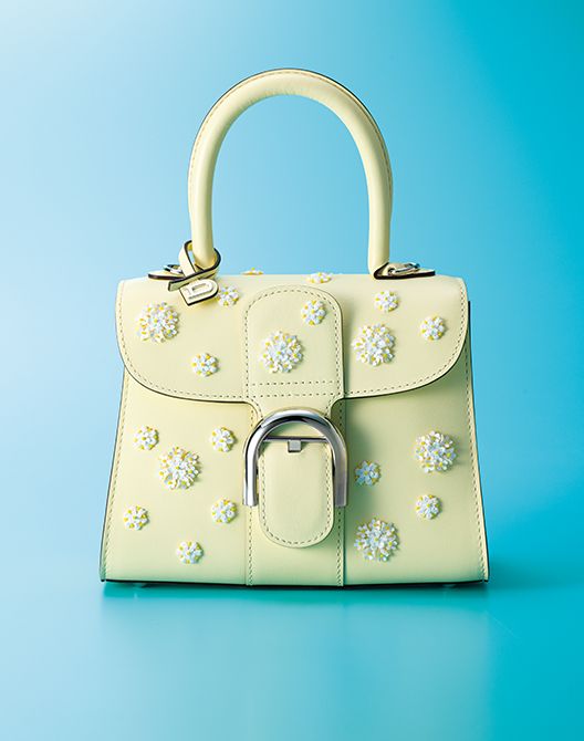 立体的なレース、花モチーフのスパンコール、 黄色のガラスビーズなど、さまざまな素材を 駆使して緻密に作られたデイジーの刺繡。花 の大きさをリズミカルに変え、立体的に彩る ことで、奥行きのある表情に。職人が約10 時間かけて、上質なボックスカーフに一つ一 つ手縫いで仕上げています。バッグ「ブリヨ ン ミニ スイートデイジー」（縦16×横20×マ チ11.5㌢)114万5100円／デルヴォー　●お 問い合わせ／デルヴォー03-6432-9125