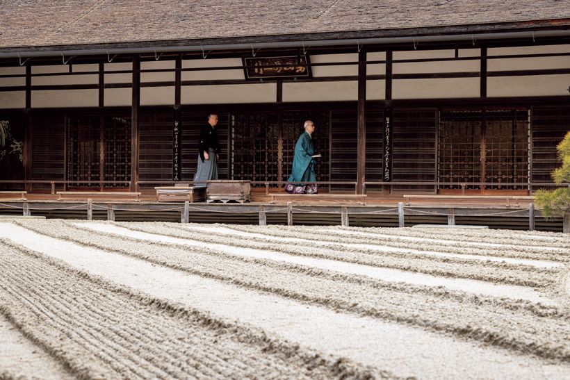 家元継承式に臨むため、威儀を正し、本堂の廊下を渡る蜂谷宗玄さんと宗苾さん。廊下の先には義政公が祀られる東求堂がある。本堂前の砂盛は、銀閣寺の見どころの一つとされる白川砂を波状に整えた「銀沙灘(ぎんしゃだん)」。