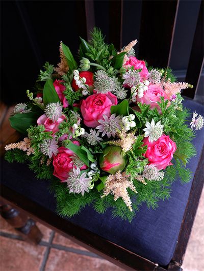 お祖母様から女の子のお孫さんへ、お誕生日の贈り花です。広島県廿日市市の「とくなが園芸」さんから届いた鮮度のよいバラ‘ローズシノ’と‘ローズメイ’にアストランティア‘フローレンス’や染めのアスチルベ‘アプリコット’を合わせました。シャクヤク‘コーラルチャーム’の大きな蕾が開くとさらに華やかな印象になります。ローズゼラニウムやアスパラガスなどをあしらってナチュラルな雰囲気に仕上げました。
