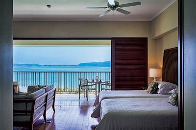 一日中海とともに過ごせる客室「クラブデラックスオーシャン 2ベッドルーム」。入り江の向こう、海越しには名護の街も見える。