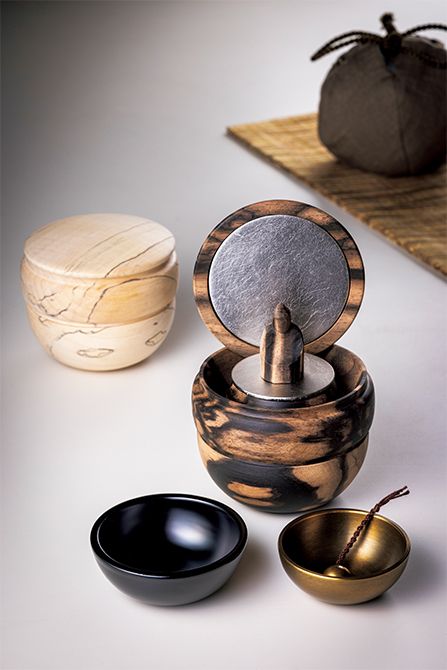 棗形の携帯厨子。本尊には少量のお骨を納められる。専用巾着付き。「携縁」（幅7×奥行き7×高さ6.1センチ）　右・「黒柿」、左・「縞栃」各19万8000円／ともに厨子屋 銀座本店