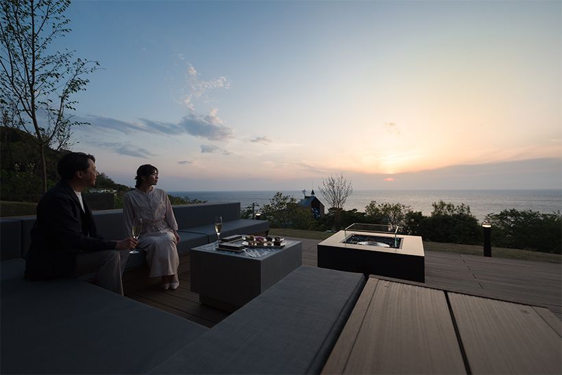 「夕陽見テラス」には5～7人ほどが座れるテラス（写真上）が計2セットのほか、ガラス張りの窓がある室内の空間も。日が沈むころには奥にある焚火に火がつく。