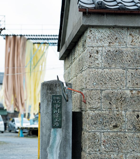 現在の田川沿いに工場が移ったのは戦後のこと。広い敷地の入り口には宇都宮を象徴する重厚な大谷石の蔵を据え、その奥に昔ながらの染め場や反物を干すために用いる背の高い櫓（やぐら）が連なります。