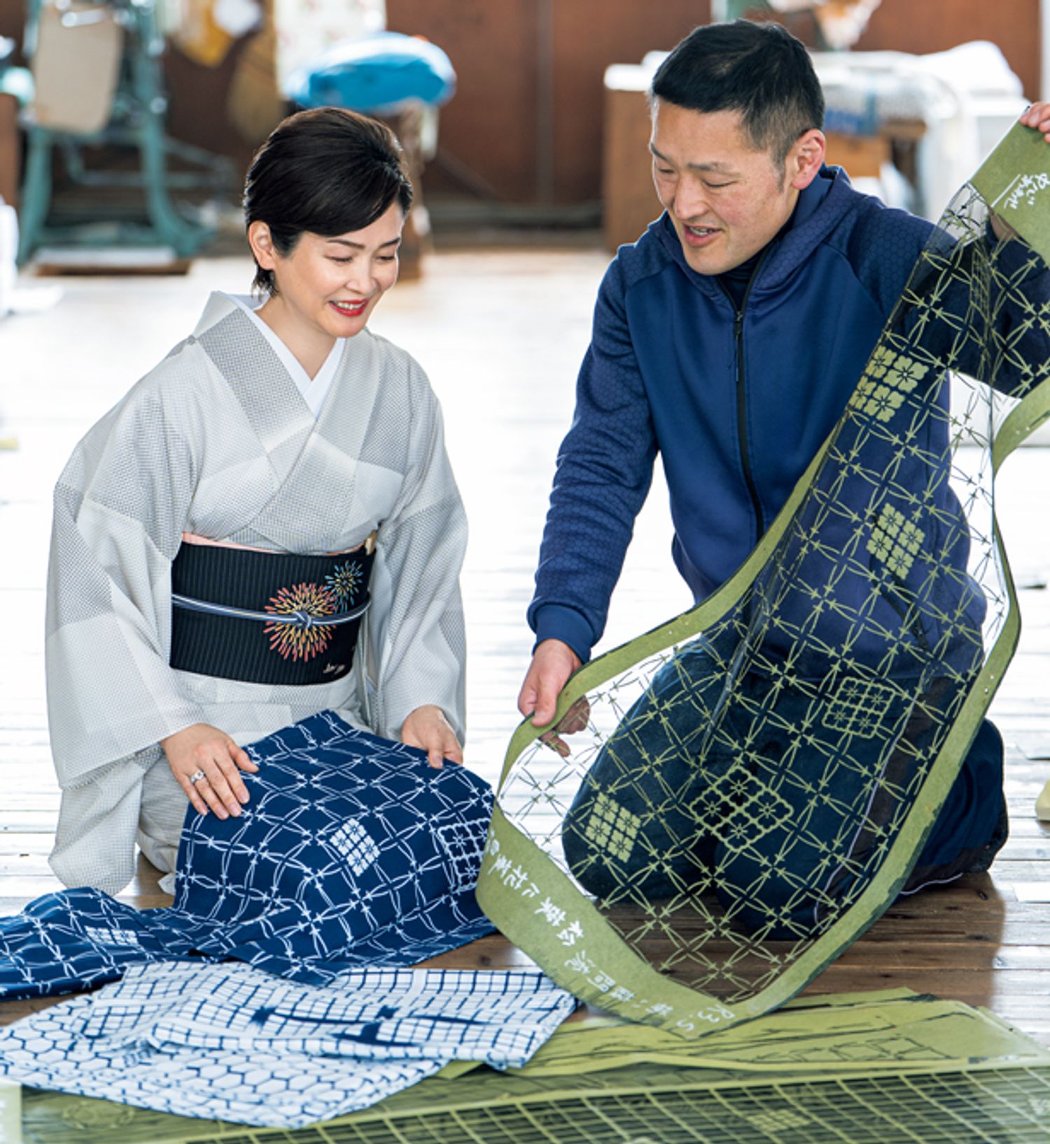 この日持参した幸四郎丈の浴衣と、型を見比べる藤間さん。中川さんが持っているのは、同じデザインでも白地の浴衣を染めるための型。透けた部分には防染糊が置かれ、型の部分が色に染まります。