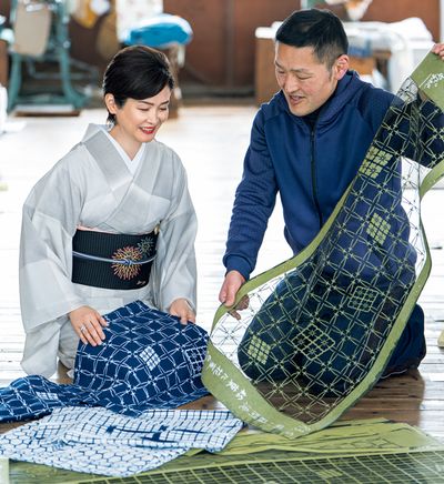 この日持参した幸四郎丈の浴衣と、型を見比べる藤間さん。中川さんが持っているのは、同じデザインでも白地の浴衣を染めるための型。透けた部分には防染糊が置かれ、型の部分が色に染まります。