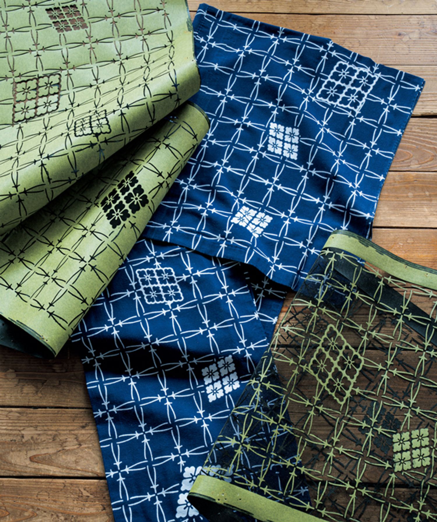 “松”本“幸四”郎にちなんだ松葉格子に、高麗屋の定紋の四つ花菱を飛ばした洒落のきいた小粋な意匠。一つの図案に対して紺地と白地を染めるため、型紙も2種類作られます。左上は“地染まり”という紺地の浴衣の型紙。右下は、白地に紺で柄を染め出すための型紙。