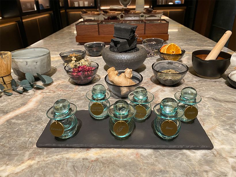 施術で使用するアロマオイル。中央はホテルオリジナルの桜。周りのものは、1988年の開業から現在まで「バンフ スプリングス ホテル」で使用されているフェアモントと繋がりの深いクリスチャン・フローリアンのもの。後ろは全ての施術の前に行うフットリチュアルですりおろして使うフレッシュなジンジャーやオレンジ。
