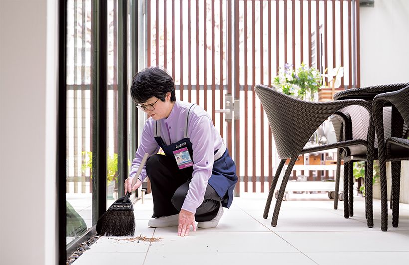 サービス当日。宮澤邸では困り事の筆頭である中庭の掃除から開始。中 庭の縁に溜まった落ち葉や敷石の中に入り込んだ木の枝、窓の桟のホコ リなどを専用ブラシや手を使ってきれいに。目につくごみを取り除いて から、広いタイル面をほうきで掃き、最後に拭き磨きで仕上げます。