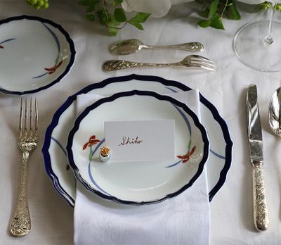 香蘭社のオーキッドレースのディナーシリーズの器を使って。瑠璃色の縁が料理を引き立て、白一色のテーブルコーディネートのアクセントにも。