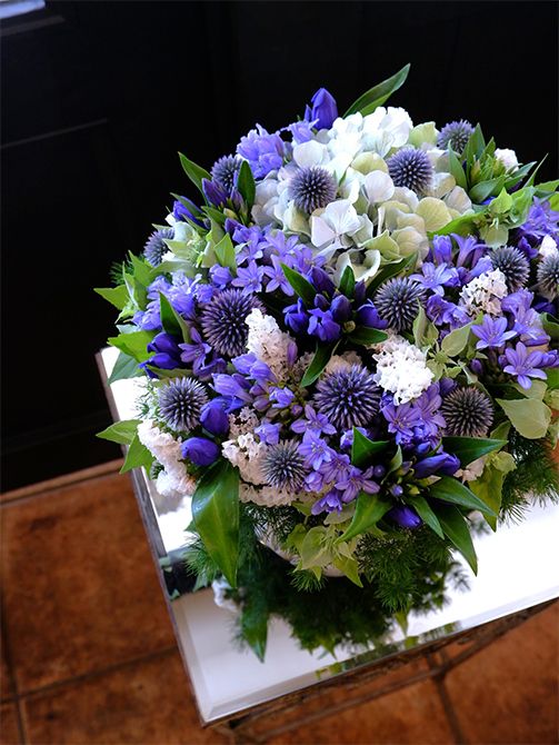 アガパンサス‘ゼラトーマス’にリンドウ‘しなの早生’、ルリタマアザミ‘ベッチーズブルー’。この時期の青花を集めてアレンジを制作しました。ニュアンスの異なるブルーが変化のある表情を生み出します。アジサイ‘ベレナクラシックブルー’とスターチス‘パルク’の白花がアレンジを明るく軽やかに見せます。愛犬をなくして悲しみに暮れる娘さんに、お母様から「元気を出して」の気持ちを込めた贈り花です。