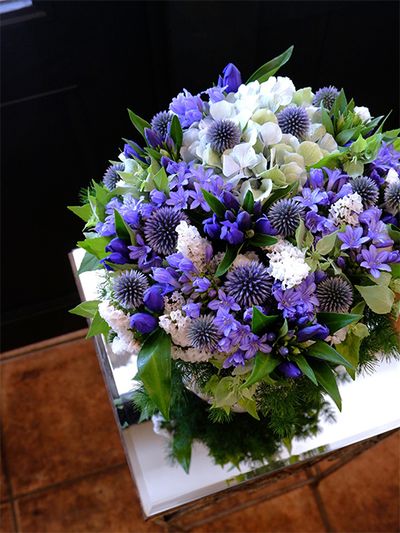 アガパンサス‘ゼラトーマス’にリンドウ‘しなの早生’、ルリタマアザミ‘ベッチーズブルー’。この時期の青花を集めてアレンジを制作しました。ニュアンスの異なるブルーが変化のある表情を生み出します。アジサイ‘ベレナクラシックブルー’とスターチス‘パルク’の白花がアレンジを明るく軽やかに見せます。愛犬をなくして悲しみに暮れる娘さんに、お母様から「元気を出して」の気持ちを込めた贈り花です。