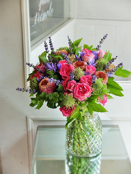 透明感のある少し淡めの青紫が美しいアガパンサス‘バイオレットブルー’を使って、ご主人から奥様へ、出産祝いのブーケを制作。あでやかな濃いピンクの花の中で、星形のアガパンサスとスマートな穂状のラベンダーという同色でも花形が異なる花を加え、アクセント効果を狙いました。濃いピンクはバラ‘ペッパーベリー’、エキナセア‘シュープリームカンタロープ。スカビオサ‘テラプチグリーン’、スペアミント、テマリシモツケ‘ルテウス’などのグリーンでナチュラル感のあるブーケに。