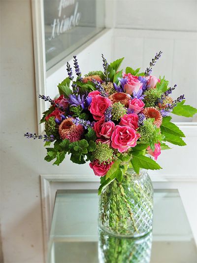 透明感のある少し淡めの青紫が美しいアガパンサス‘バイオレットブルー’を使って、ご主人から奥様へ、出産祝いのブーケを制作。あでやかな濃いピンクの花の中で、星形のアガパンサスとスマートな穂状のラベンダーという同色でも花形が異なる花を加え、アクセント効果を狙いました。濃いピンクはバラ‘ペッパーベリー’、エキナセア‘シュープリームカンタロープ。スカビオサ‘テラプチグリーン’、スペアミント、テマリシモツケ‘ルテウス’などのグリーンでナチュラル感のあるブーケに。