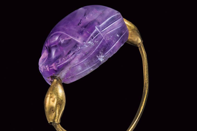 紀元前1991～1650年頃エジプトで作られた指輪《スカラべ》。カボションカットのアメシストは古代エジプトで再生の象徴とされたスカラベ（甲虫）をかたどったもので、その頭から尾までを貫く穴に金線が通っている。亡き王の復活を願う護符として棺に納められていたものか。