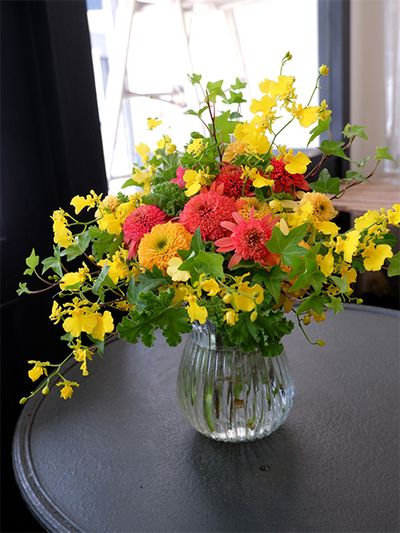 エキナセアの‘ラズベリートリュフ’と‘レモンドロップ’、オンシジウム‘ハニードロップと、’夏らしいオレンジ色と黄色の花色合わせのブーケです。こちらも市場のイベント用に制作したもので、「南原農園」さんのアップライトアイビー‘ピッツバーグ’を利用し、ほかにグリーンワッフルゼラニウムを加えました。オンシジウムの枝の伸びにアップライトアイビーが寄り添います。