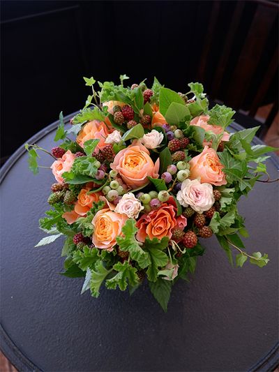 アップライトアイビー‘ピッツバーグ’、キイチゴ‘ベビーハンズ’、グリーンワッフルゼラニウムと、たっぷりのグリーンの中に、バラの‘ビーハイブ’と‘カルピディーム’、‘吉野’を加えたアレンジです。ブルーベリーとブラックベリーを加え、夏のみずみずして収穫シーンのイメージに仕上げました。暑さを見舞う贈り花です。