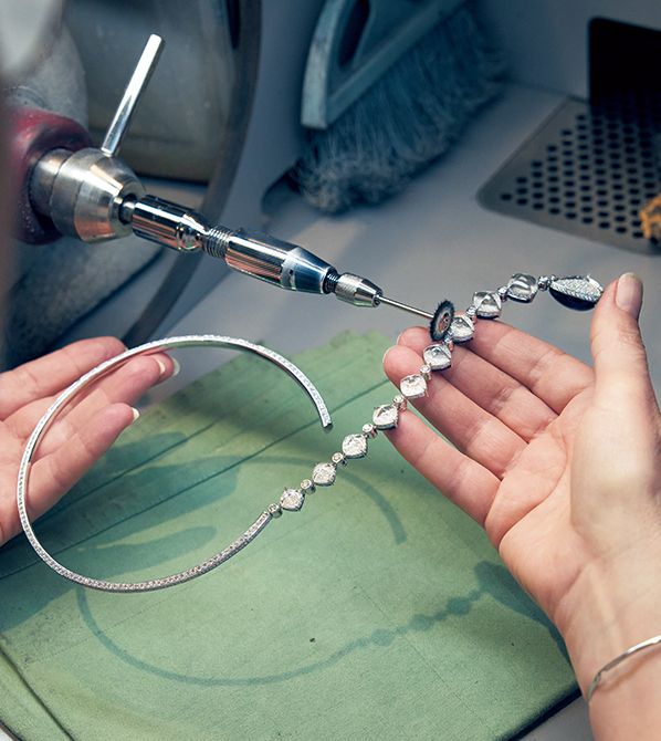 ブシュロンの革新性を象徴する「クエスチョンマークネ ックレス」。表面はもちろん裏側にも丁寧な磨きをかけるこの工程に特化して技を極めた職人の手もと。