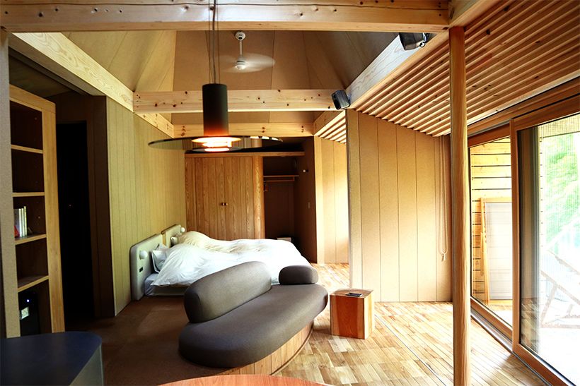 Mediumタイプの客室の一例。1ルームタイプで、入口から、コンパクトなキッチンとダイニングテーブル、ソファへとつながり、奥にはセミダブルベッドが2台ある。