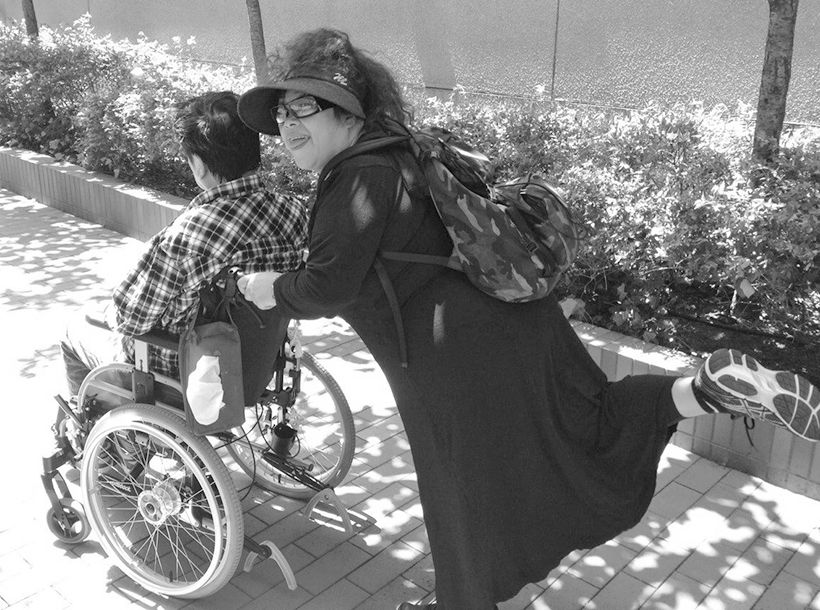 軽やかにご主人の車椅子を押す森さん（2014年5月）。「外出先で困っても躊躇なく周囲に助けを求められるようになりました」。