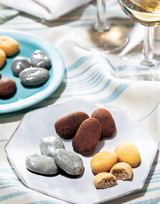 盛りつけた3種は左手前から時計回りに、黒ごまペーストを練り込んだホワイトチョコレートでコーティングした「黒胡麻」、「ココアがけ」、すっきりとした後味のホワイトチョコレートで包みキャラメルパウダーをまぶして仕上げた「キャンディコート」。