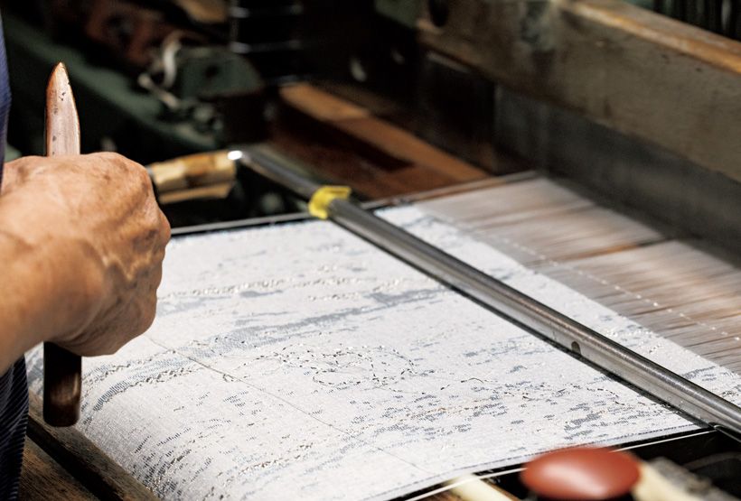 美しく織りなされていく螺鈿織。織り込まれた貝殻が煌めく。