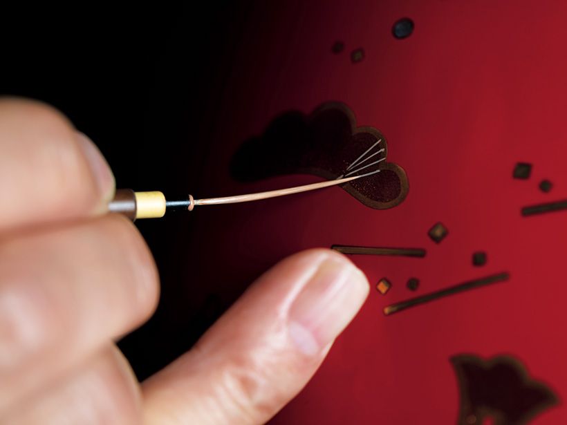 筆先が長い“蒔絵筆”の先の部分に圧をかけながら、「上絵」を描いていく。