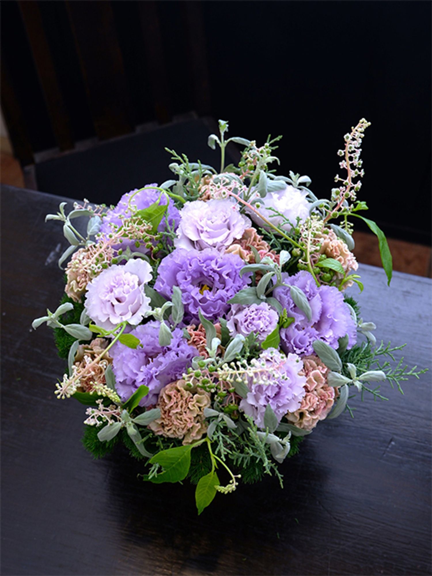 淡い青紫の花を集めたアレンジでは、ケイトウ‘プティフルーツ フェアリーローズ’がほどよいアクセントに。ベージュがかったピンクに少し緑色も含むケイトウのニュアンスのある花色がしゃれています。こちらもお誕生日の贈り花です。