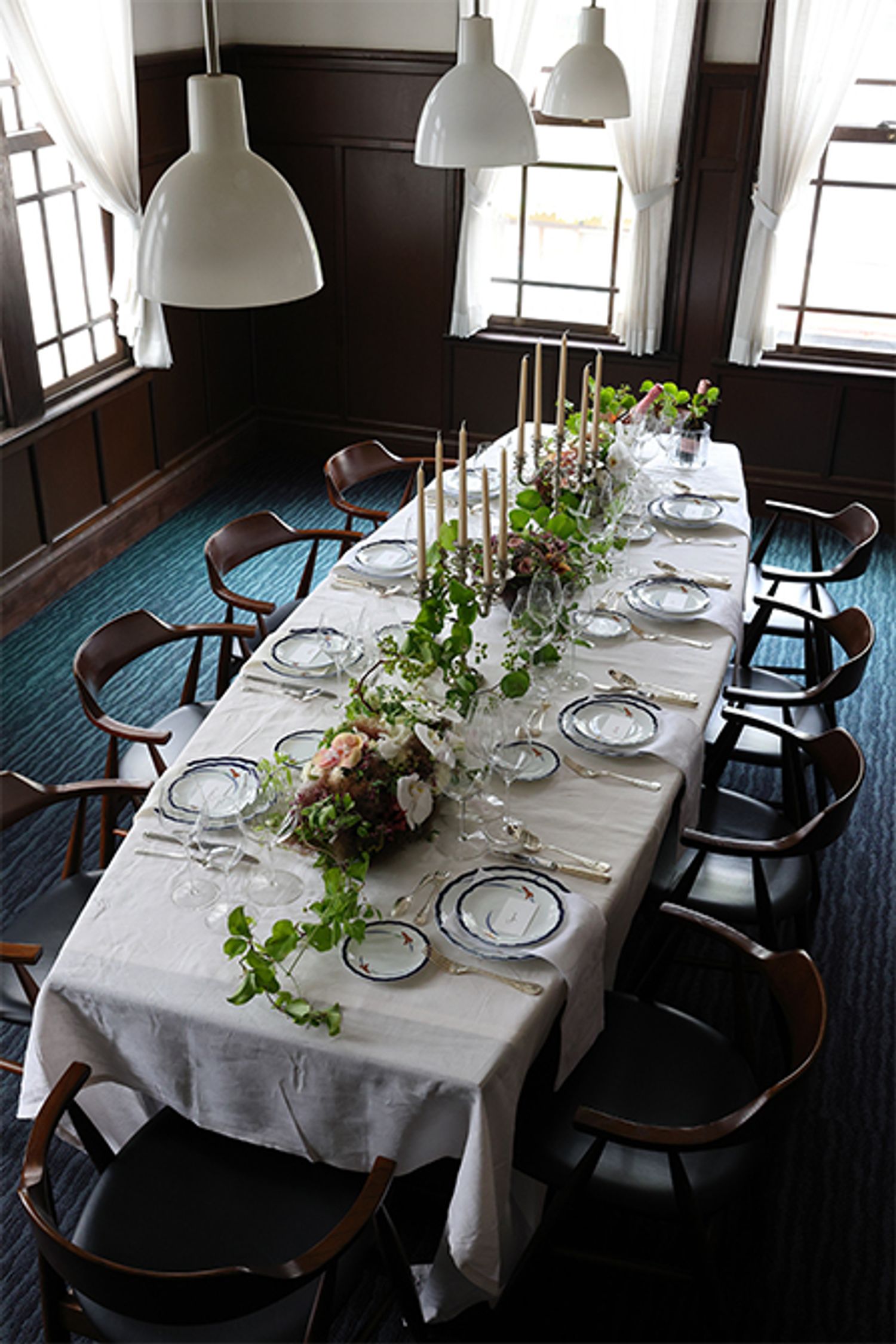 〔正餐〕の実例：現代ではなかなか設える機会のない本格的なディナーセッティングです。1905年（明治38）に建てられた香蘭社本館の天井の高い応接室は、正餐の場にふさわしいクラシックな雰囲気。社名にもある蘭をモチーフにしたオーキッドレースのディナーシリーズをフルセットで使いました。『名窯を巡る、季節を飾る　有田焼で楽しむテーブルコーディネート』より。