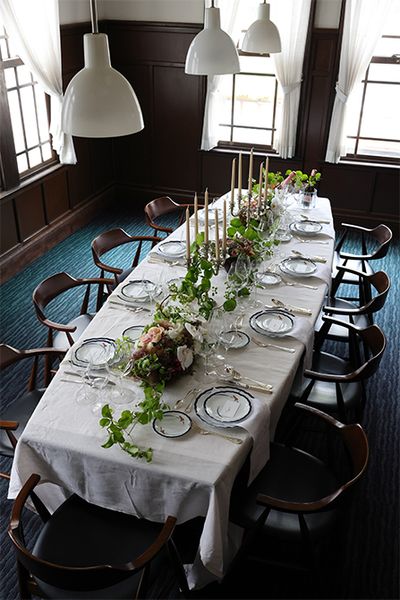 〔正餐〕の実例：現代ではなかなか設える機会のない本格的なディナーセッティングです。1905年（明治38）に建てられた香蘭社本館の天井の高い応接室は、正餐の場にふさわしいクラシックな雰囲気。社名にもある蘭をモチーフにしたオーキッドレースのディナーシリーズをフルセットで使いました。『名窯を巡る、季節を飾る　有田焼で楽しむテーブルコーディネート』より。