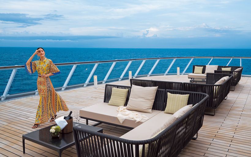 【ASUKA Ⅲ】2025年7月就航。客室数381室（全室海側バルコニー付き）、乗客定員740名、全長230メートル。写真は飛鳥Ⅲの船尾に位置するテラス。ここでは「グリルレストラン パペンブルグ」の炭火焼き料理が楽しめる。ゆったりとくつろぎながら、刻々と変わりゆく海と空の景色を眺める時間は最高の贅沢。 ドレス39万3800円　椅子に置いたストール7万9200円／ともにエトロ ジャパンピアス84万7000円　バングル478万5000 円リング225万5000円／すべてブチェラッティシューズ／スタイリスト私物