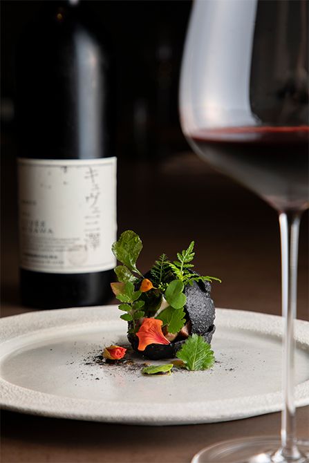 竹炭を練り込んだ生地の球体の中に、猪や鹿のローストや煮込みなど数種類のジビエ肉を閉じ込め、庭に生える野草やハーブを添えて。ジビエ出汁にクロモジの香りを移したソースが清涼感を誘い、従来のジビエ料理とは一線を画した爽やかな余韻の一品に。ワインには、山梨の女性醸造家・三澤彩奈さんが手掛ける傑作「キュヴェ三澤 2015」をセレクト。
