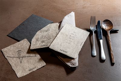 山梨県身延町の名産・西嶋和紙を、ヤマブドウやドクダミで染めた品書き。兄の茂一郎さんが描いたキビタキがゲストを迎える。