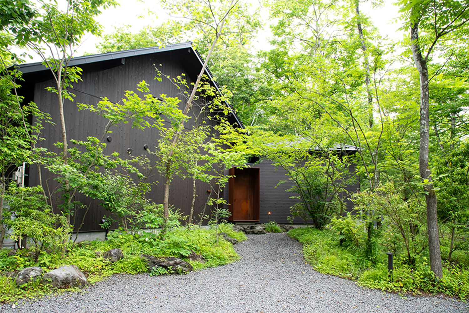 森の中の隠れ家のような佇まいの「nôtori」。きれいに手入れをしすぎない、程よく手付かずな自然の形をキープしたランドスケープデザインに。「建設の際、この土地に元々生えていた野草は刈り取らずにポットに植え替えて、今も大切に守っています」と浩平さん。