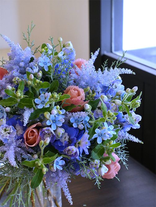 初孫誕生を祝い、お義母さんからお嫁さんへの贈り花です。オキシペタラム‘ピュアブルー’、デルフィニウム‘オーロラ ブルーインプ’、染めのアスチルベ‘ライトブルー’、とニュアンスが少しずつ異なるブルーを集め、バラ‘ジュリア’とコニファー‘ブルーアイス’を加えて束ねました。オキシペタラムの星形がくっきりと目立つブーケになりました。