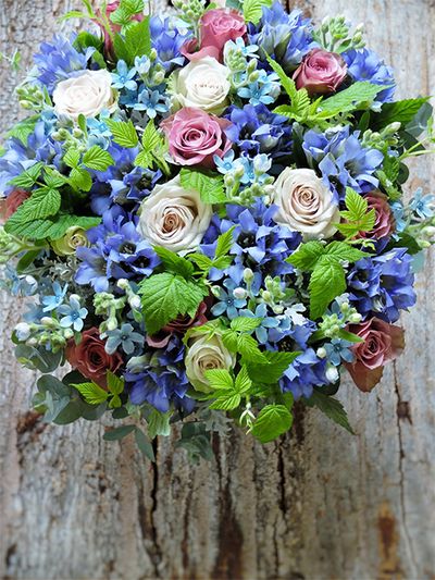 ブルーの花が好きな妹さんへ、お姉さんから誕生日を祝う贈り花です。オキシペタラム‘ピュアブルー’とリンドウ‘深山淡麗’、色みが少し違うブルーを合わせ、落ち着いた花色のバラ‘アヴニール＋’と‘デザート’でボリュームアップしたアレンジです。フランボワーズやユーカリを加えてナチュラル感のある仕上がりに。